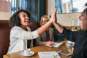 women high-fiving